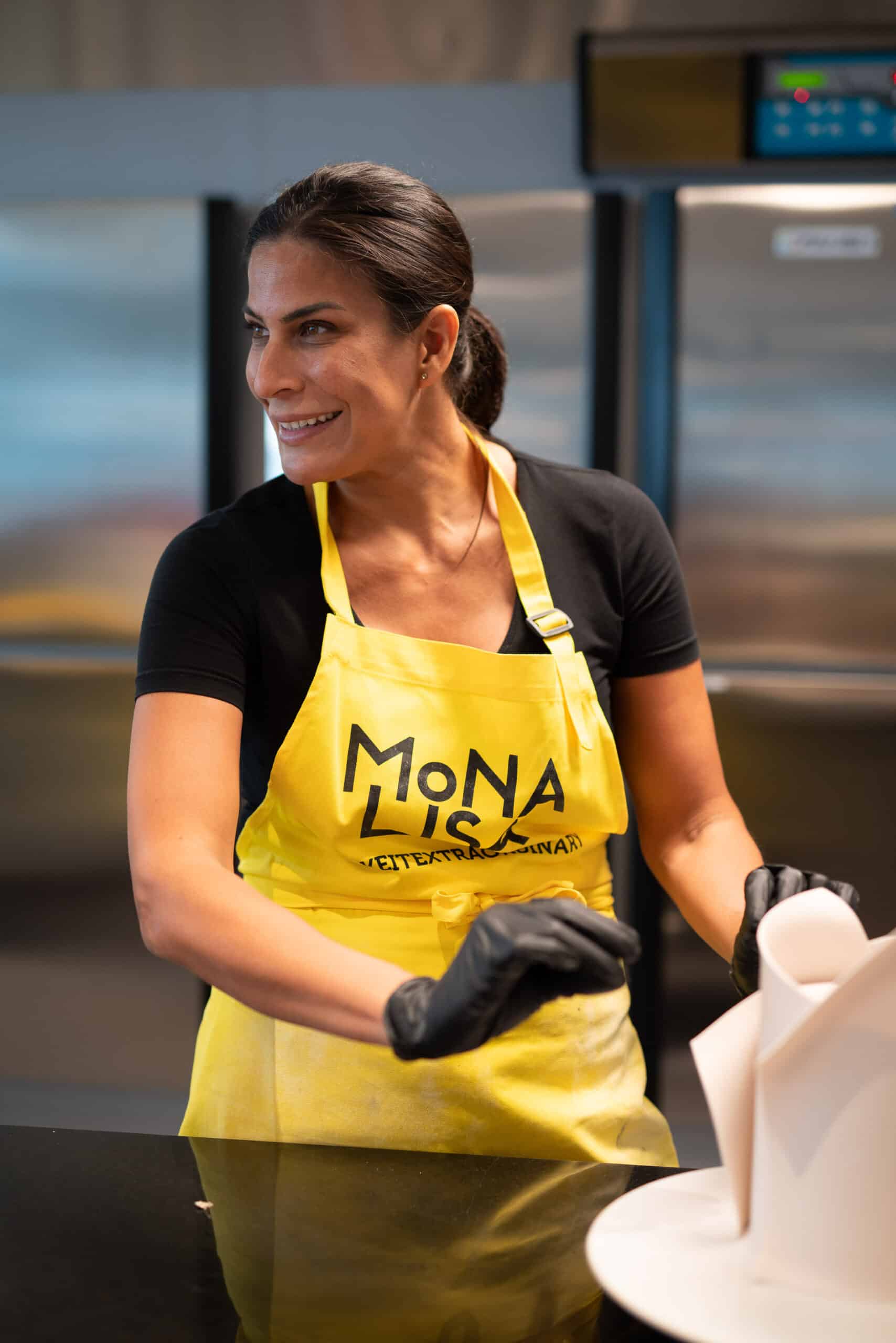 Kursleiterin gelbe Schürtze Küche Workshop Mona Lisa Chocholate Academy Eventfotografie Zürich Schweiz BeLighted