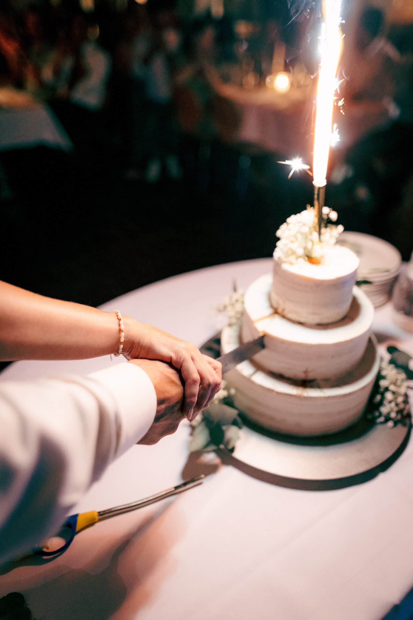 Hände Messer Hochzeitskuchen Feuerwerk anschneiden Brautpaar Hochzeit glücklich Paarbilder Hochzeitsfotografie Hochzeitsfotograf Schweiz BeLighted