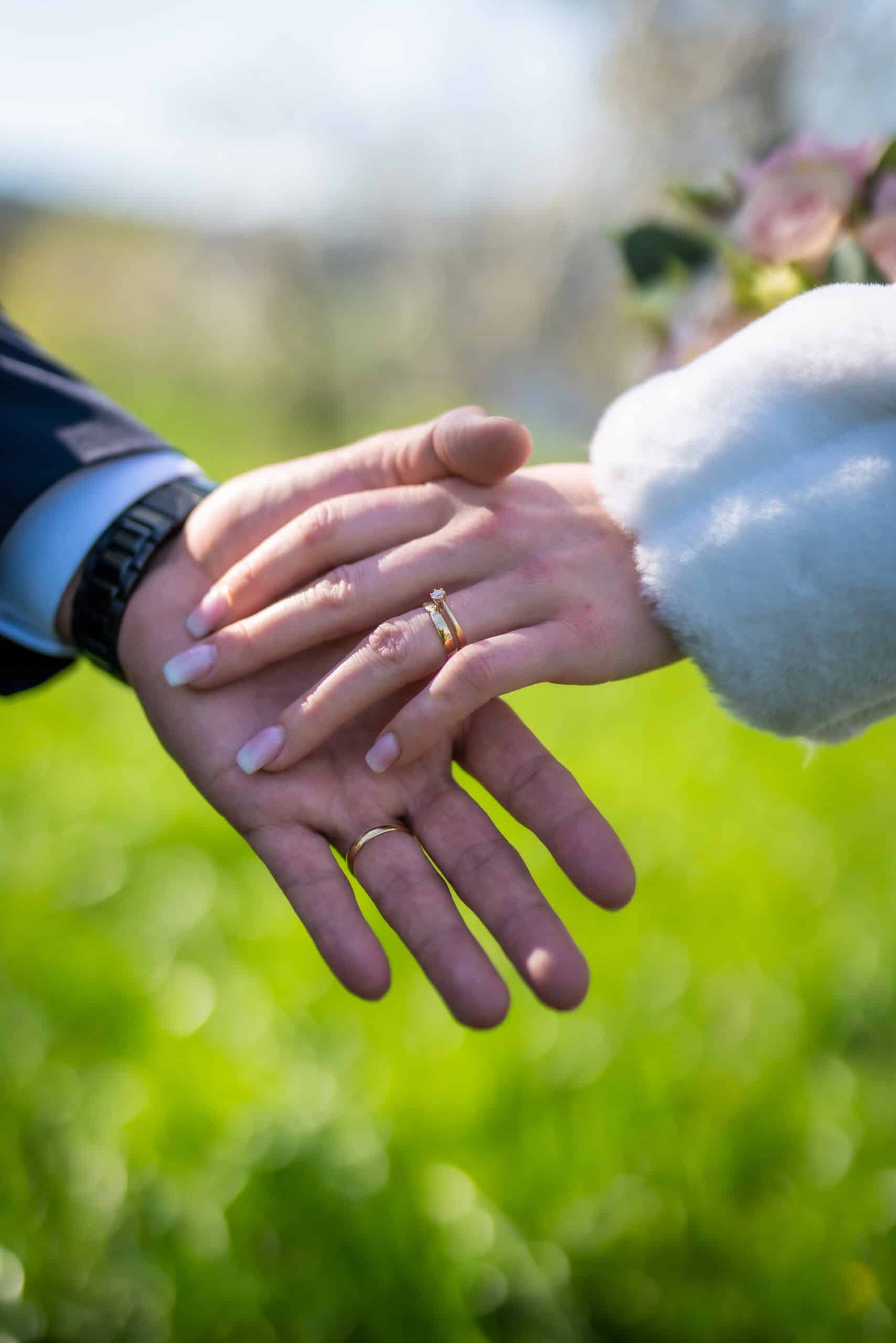 Paar Hände Ringe Hochzeit Wiese Blumen Hochzeitsfotografie Hochzeitsfotograf Schweiz BeLighted