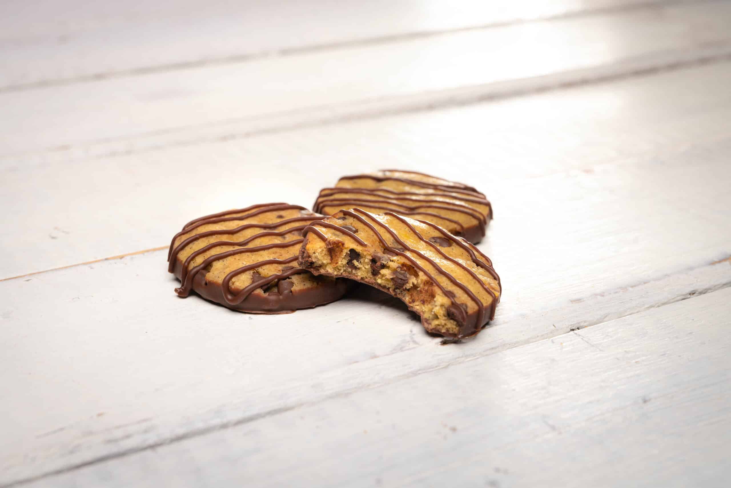 drei Cookies angebissen weiss Holzbrett neutral hell Produktfotografie Schweiz Zürich BeLighted