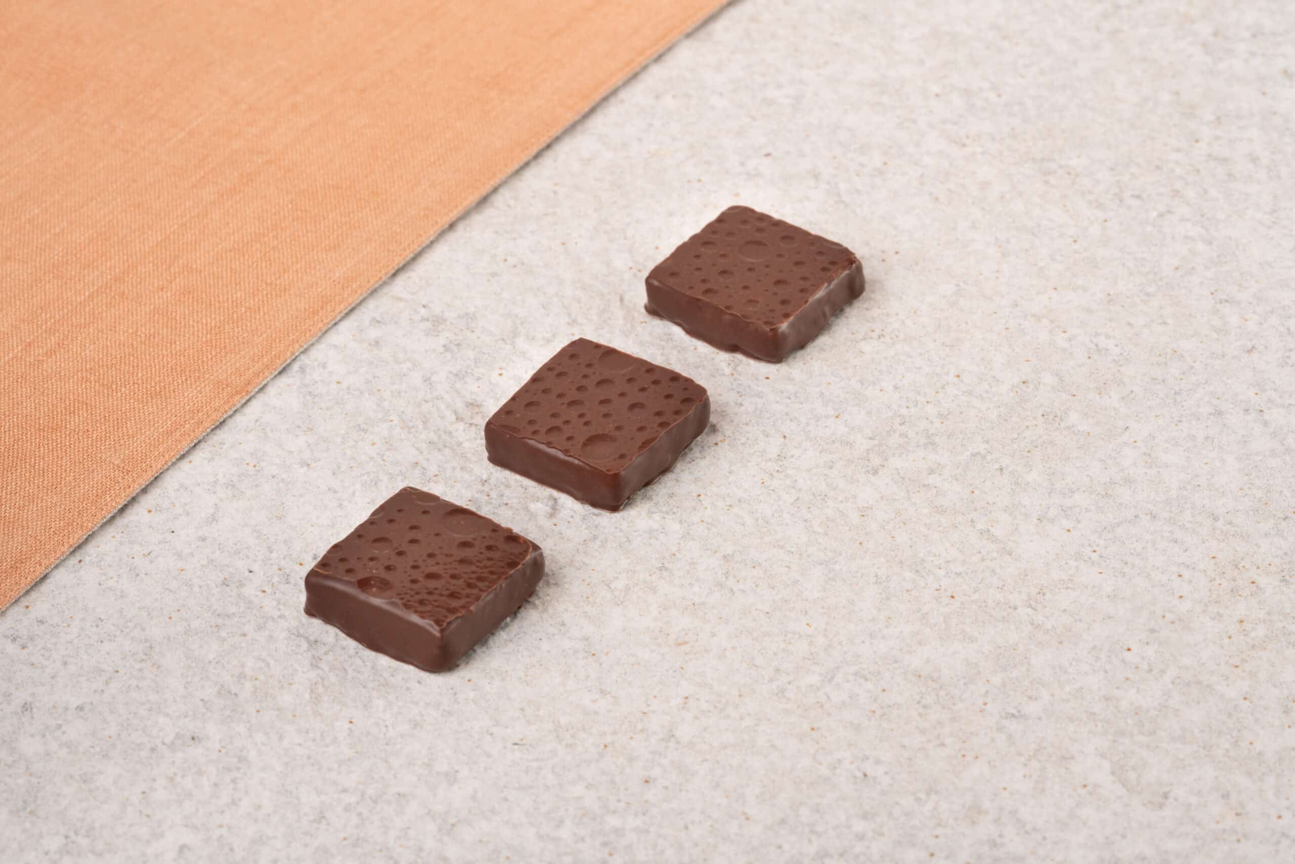 Bonbon Geometrie drei orange Tuch Dreieck Tarte seamless Produktfotografie Schweiz Zürich BeLighted